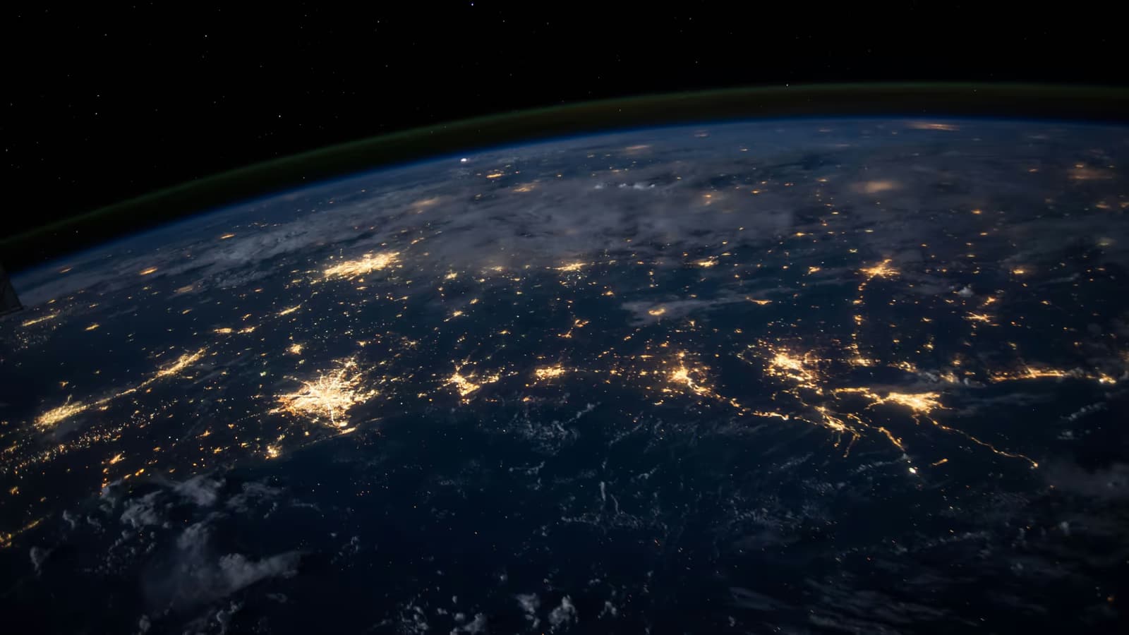 Earth at night seen from satellite with city lights — metaphor for globally interconnected surveillance.