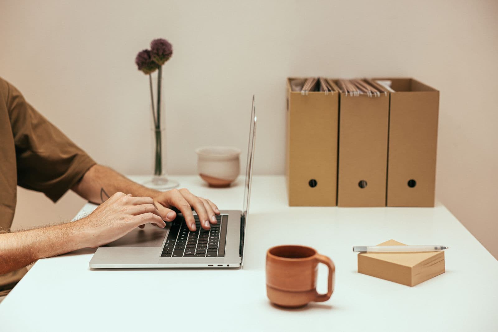 Hands typing on a laptop in a minimalist workspace. Anything you upload to a non zero-knowledge cloud is readable by the provider's systems, which is what makes automated scanning possible.