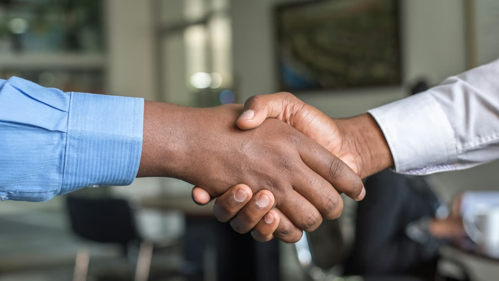 Business handshake between two people — metaphor for legal negotiation between regulatory frameworks.