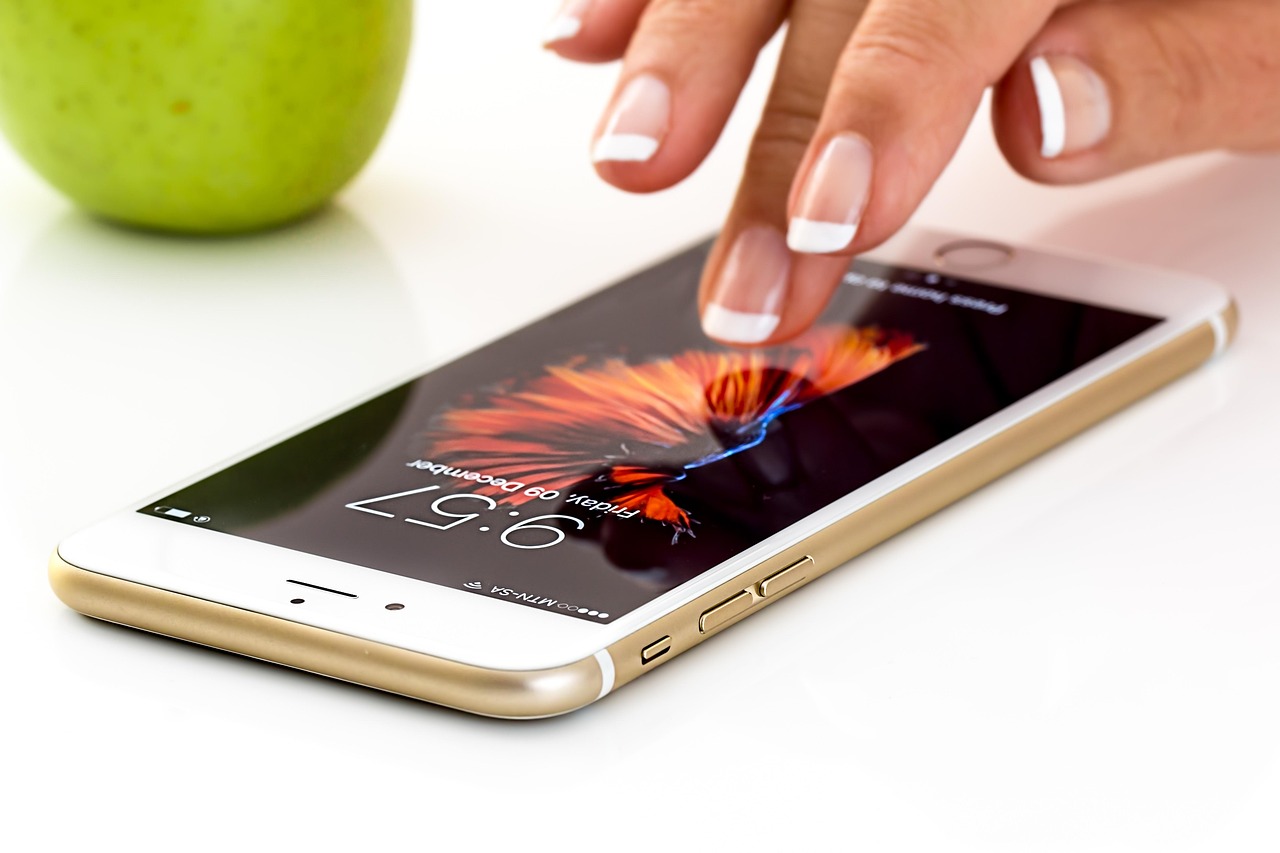 A hand holding a smartphone showing apps